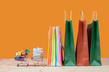 Paper shopping bags and trolley carts with full of gifts on the wooden table. concept. Concept online sale. sale