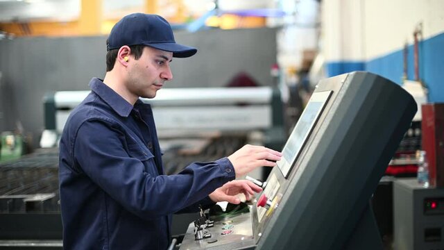 Worker operating a machine in a factory