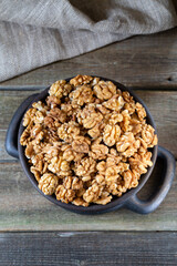 Walnuts in round bowl on wooden rustic background 