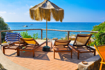 Beach chairs and umbrellas in front of the sea.