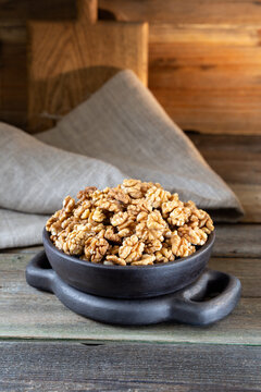 Walnuts in round bowl on wooden rustic background 