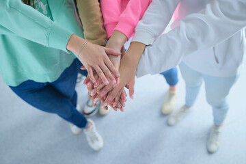 People joining hands, young women standing together