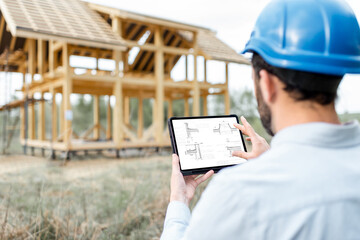 Architect or builder using digital touchpad on the construction site outdoors. Close-up on screen...