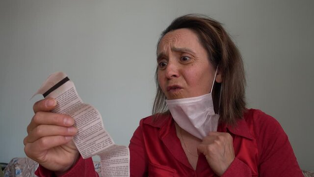 Fethiye, Turkey - 20th of May 2020: 4K Lockdown reality - Shocked woman takes off her face mask on reading the bill
