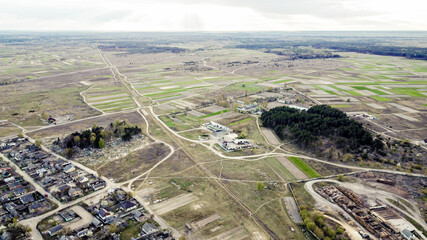 View from the drone to the railway station, the wood processing plant and the village street near the narrow-gauge railway. Sunny spring day. Zarichne village, Polissya, Ukraine