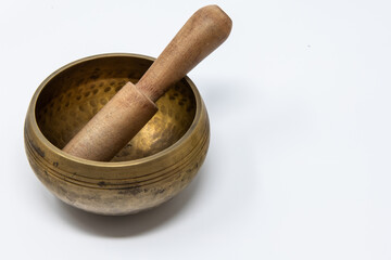 Objects for yoga and moments of relaxation at home. A Tibetan brass bell photographed on a white background.