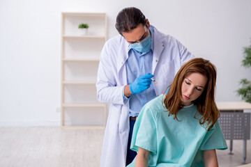 Young back injured woman visiting male doctor chiropractor