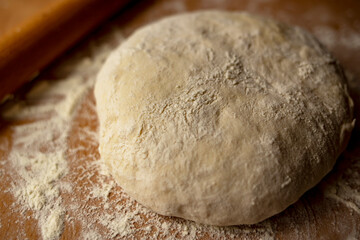 Fototapeta na wymiar Fresh homemade dough on a wooden table. Side view.