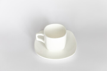 Empty white cup on saucer on white background