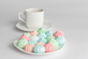 Good morning. meringues and a cup of coffee on a saucer on isolated a white background. Coffee culture concept.