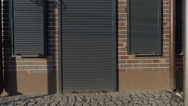 background, texture, view of the facade of the red brick building with brown rollers on the windows and doors