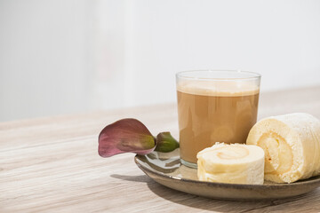 Brazo de gitano casero con café con leche desayuno romántico con flor
