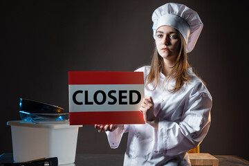 Restaurant devastation. Restaurant chef holds plate closed. Woman in cook clothes with signboard...