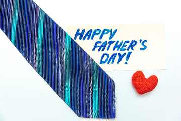 Happy Father's Day inscription with tie and gift box on blue background. Greetings and presents