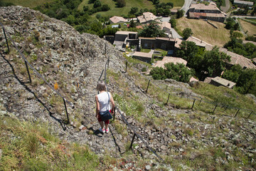 Femme touriste descendant un chemin escarpé d'un sommet volcanique