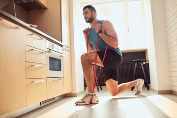 Athletic gentleman doing exercise with elastic fitness band