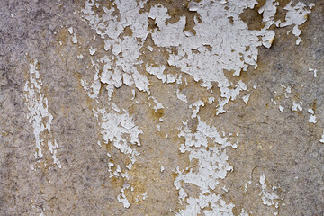 Texture of old peeling paint of white color on the wall.