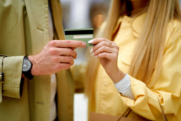 Fototapeta premium cropped photo of people holding discounts card, man give discounts card to woman, going to go shopping