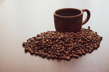 Brown ceramic cup with painted patterns. Coffee cup on the table.