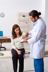 Obraz premium Young hand injured woman visiting male doctor traumatologist