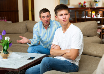 Man scolding his offended young son