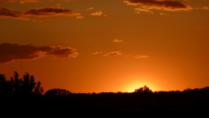 Fototapeta na wymiar Orange sunset on the cloudy sky