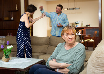 Unhappy senior woman sitting, emotional woman quarrel with man