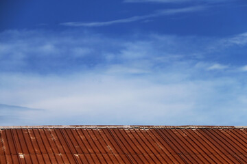 Galvanized roof old and rusty In the blue sky.