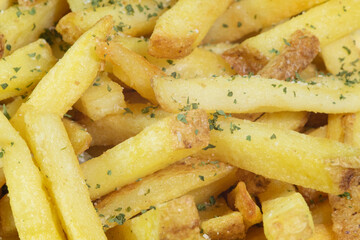 Rustic fries (potato chips) cooked with skin on. Garnished with parsley and sea salt