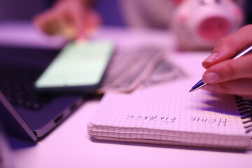 Close-up, womans hands write notepad home finances
