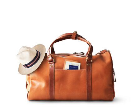 Vacation concept, large classic brown leather travel bag with hat