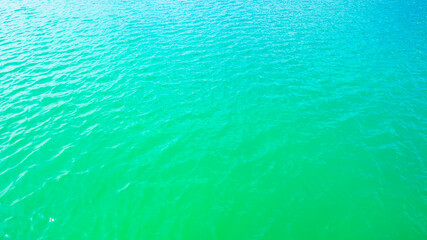 Fototapeta na wymiar Summer background - turquoise water surface with small waves in the sun light