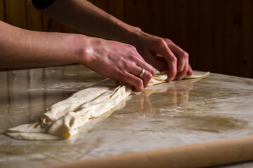 Woman, female hands preparing Balkan traditional food, cheese pie, close up