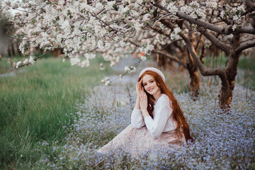 A brunette with long hair in blooming Apple orchard