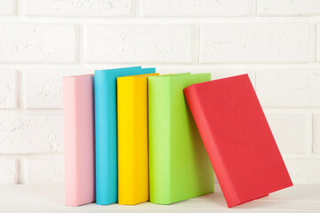 Multi coloured school books on a white background.