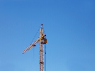 Fototapeta na wymiar Yellow crane on a background of blue sky.