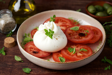 Buratta salad with tomatoes. Traditional Mediterranean appetizer. Italian Cuisine