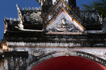 Fresco of a buddha image on the entrance gateway to a wat or temple in Siamese Lao PDR, Southeast...