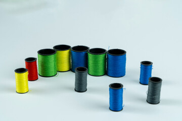 Colored spools of thread on a white background