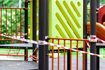 The play park for young children is wrapped in red barrier tape. Outside. Prohibition of outdoor walks, prevention of the coronavirus influenza virus covid-19. healthcare and medicine. selective focus