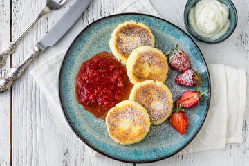 cheese pancakes with berries and powdered sugar, flowers, healthy breakfast