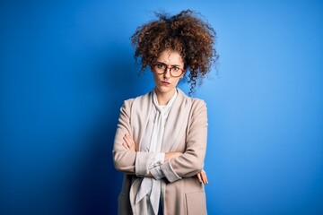 Fototapeta na wymiar Young beautiful businesswoman with curly hair and piercing wearing jacket and glasses skeptic and nervous, disapproving expression on face with crossed arms. Negative person.