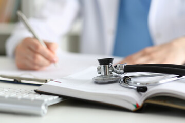 Fototapeta premium Stethoscope head lying on medical forms closeup
