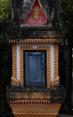 Single grave of religious person in a stupa-like design at a temple or wat site in Siamese Lao PDR, Southeast Asia