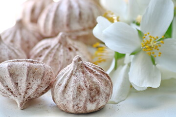 Still life of meringue dessert on a white background with jasmine flowers. This is the basis of...