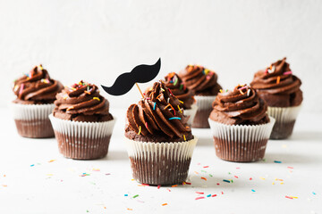 Chocolate cacao cupcakes with moustache and sprinkles decor, fathers day