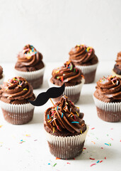 Chocolate cacao cupcakes with moustache and sprinkles decor, fathers day