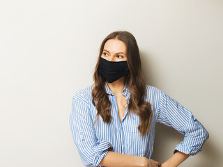 Young adult woman portrait in medicine mask on white background