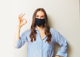 Young adult woman portrait in medicine mask on white background