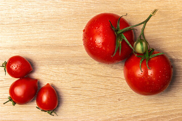 ripe, juicy, red, large and small tomatoes on a wooden table background